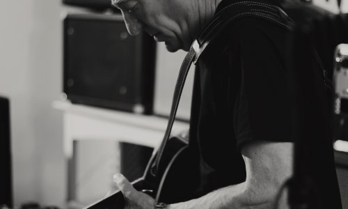 close-up of John Hern playing his guitar